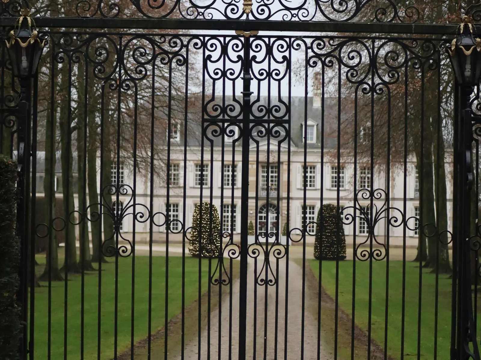 Black driveway gate installed between masonry posts